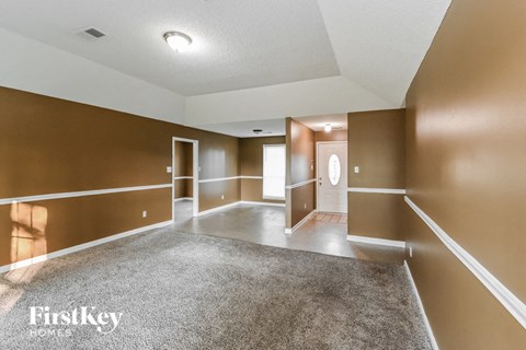 a empty living room with brown walls and white carpet