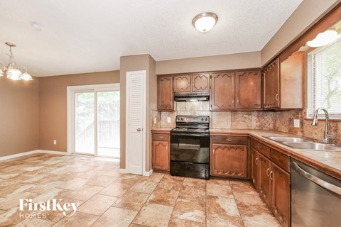 A kitchen with brown cabinets and a black oven.