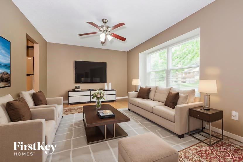 A well-lit living room with a television, two couches, and a coffee table.