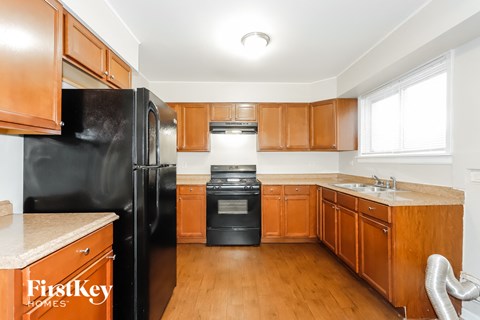 a kitchen with wooden cabinets and black appliances