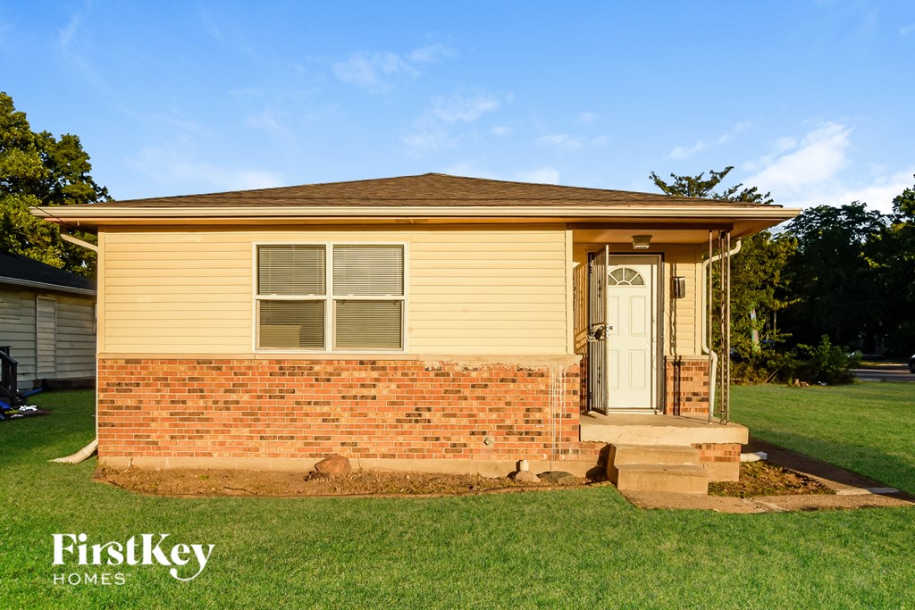 A small house with a white door and a brick wall.