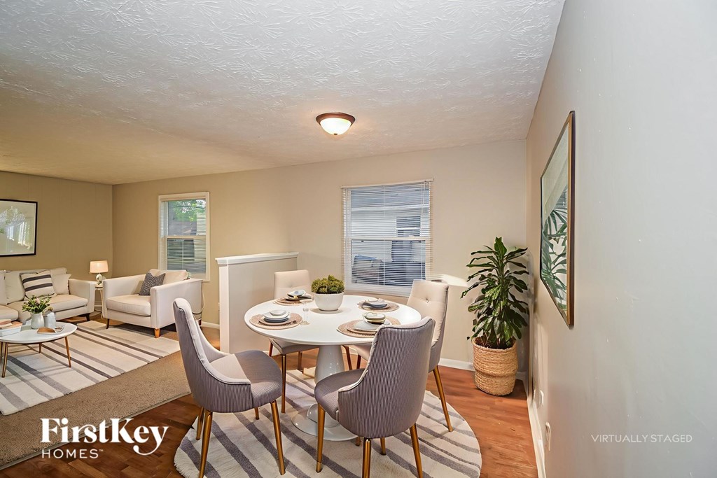 A dining room with a white table and chairs.