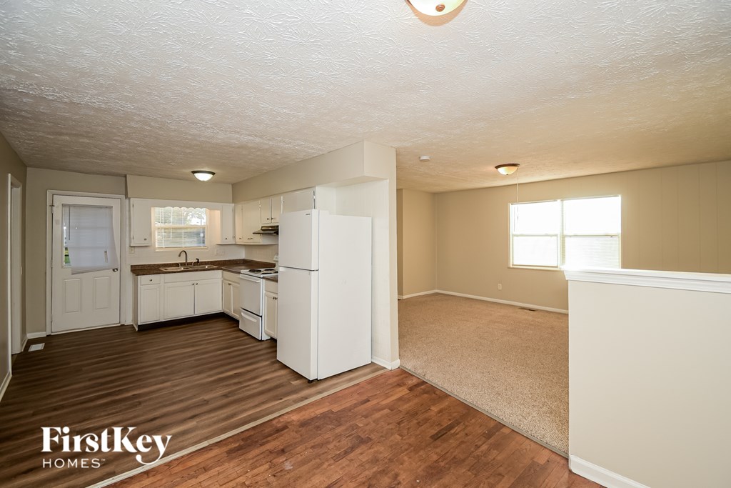 A kitchen with wooden floors and white appliances.