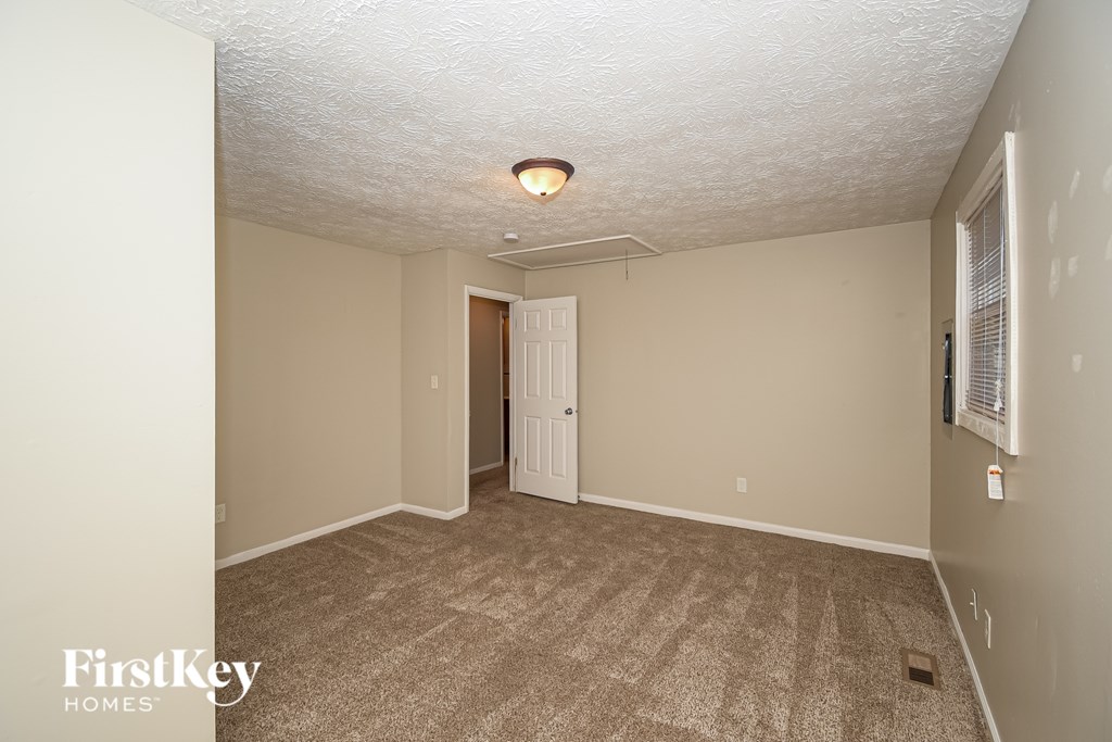 A room with a carpeted floor and a door in the middle.