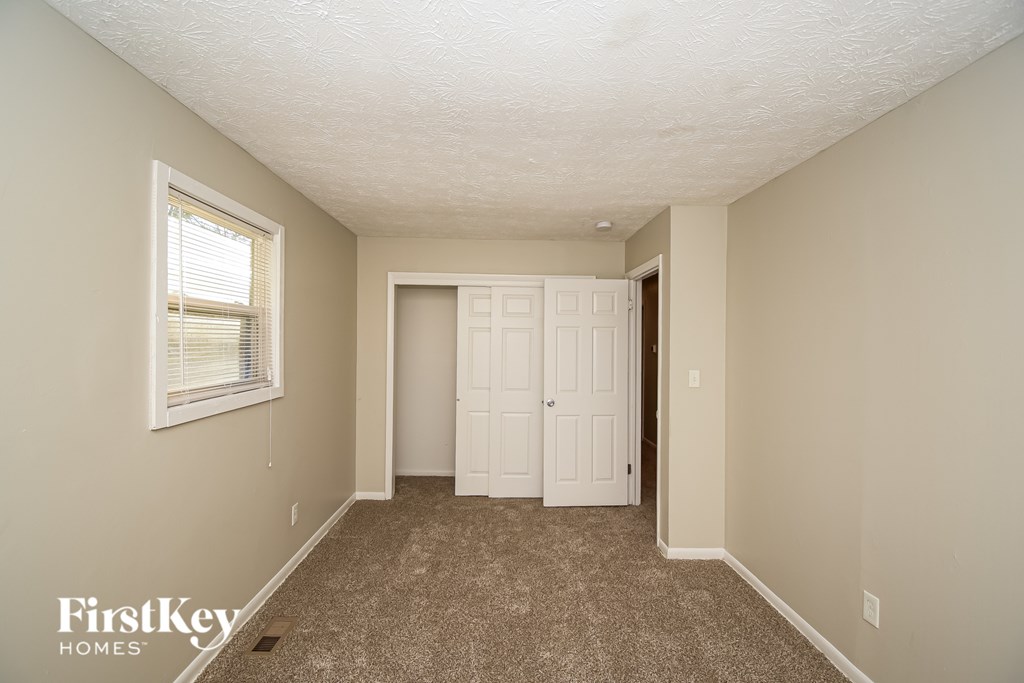 A room with a carpeted floor and a white door.