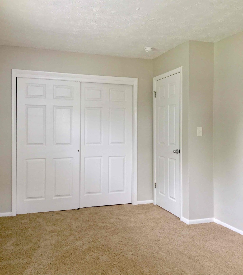 an empty room with two closets and a door