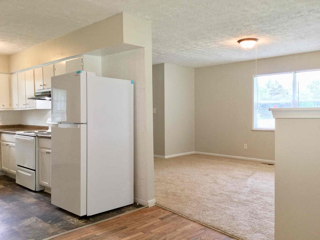 a kitchen with a refrigerator and a stove and a window