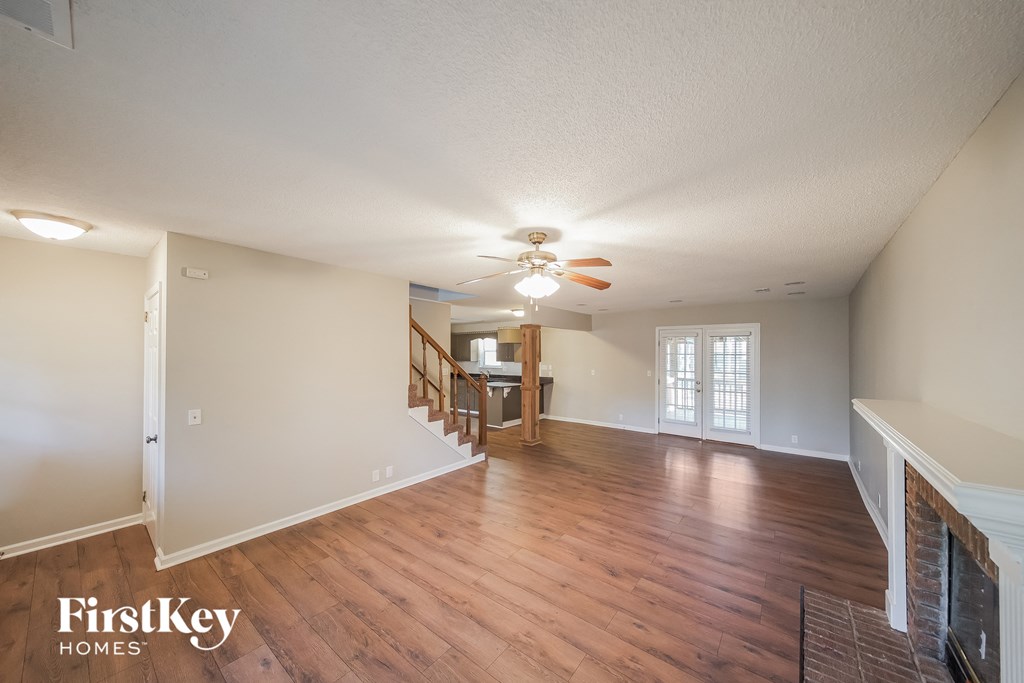 a living room and dining room with wood floors and a ceiling fan
