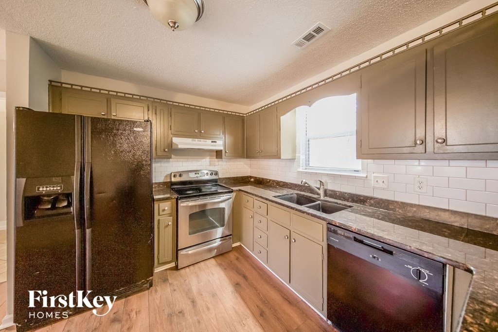 a kitchen with stainless steel appliances and white cabinets
