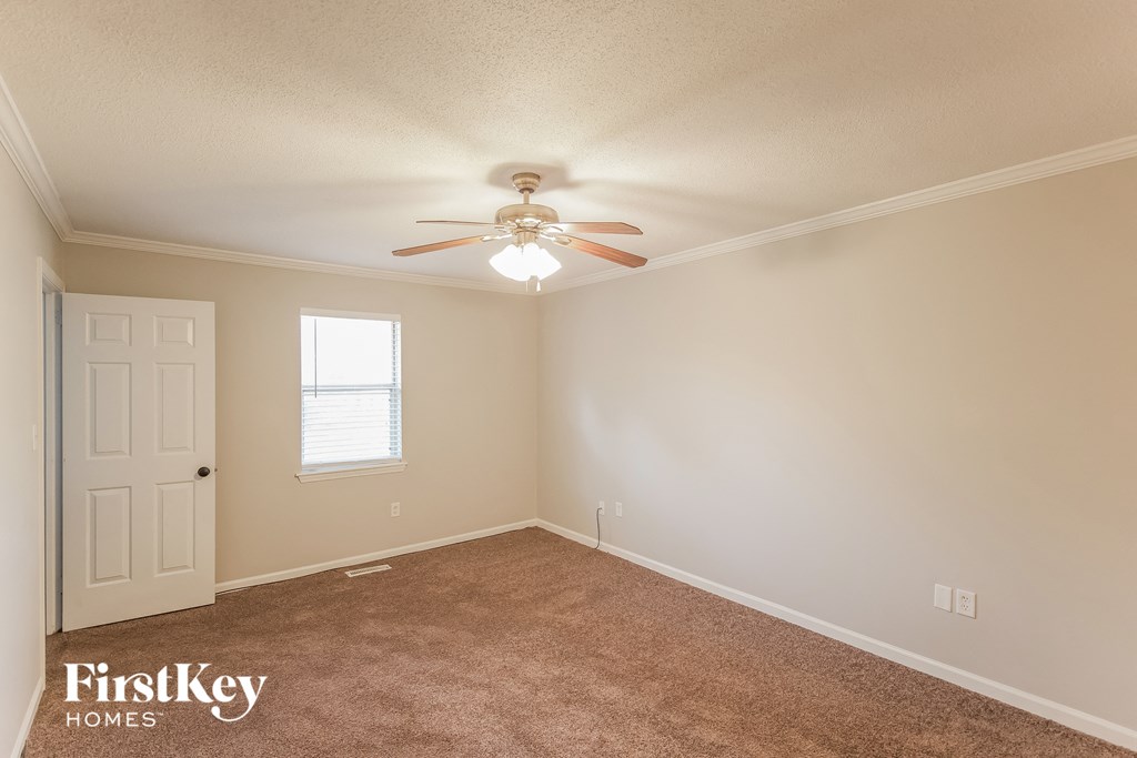 a bedroom with carpet and a ceiling fan