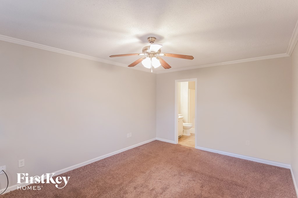 the living room has a ceiling fan and a carpet
