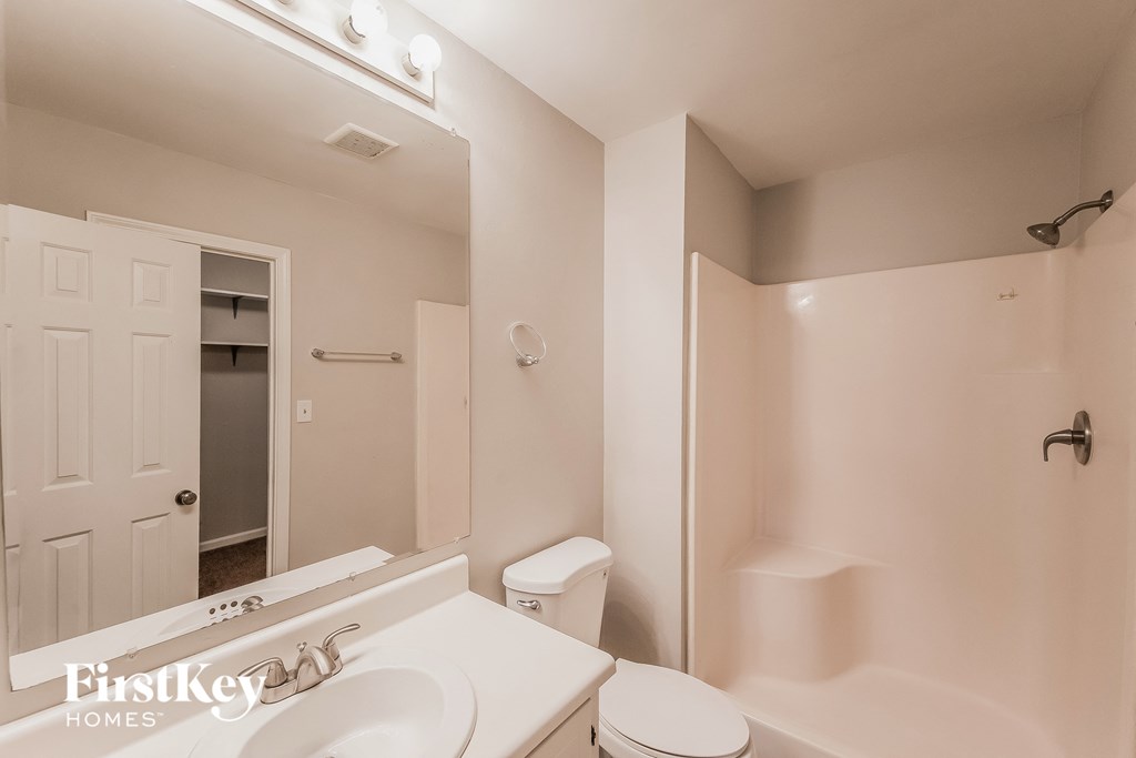 a bathroom with a white sink and a toilet and a shower