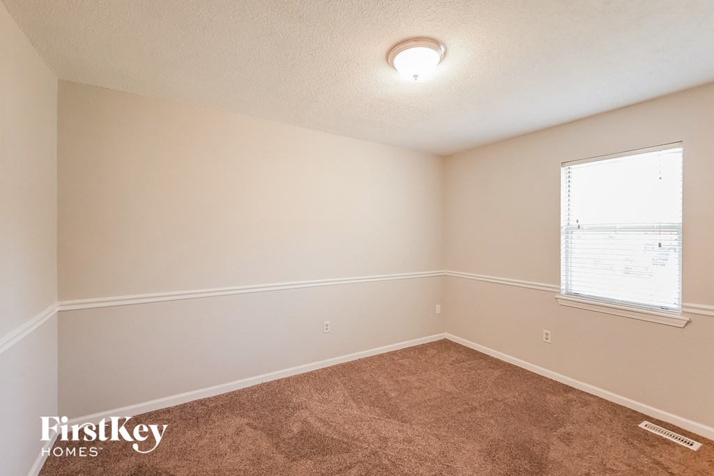 a bedroom with carpet and a window