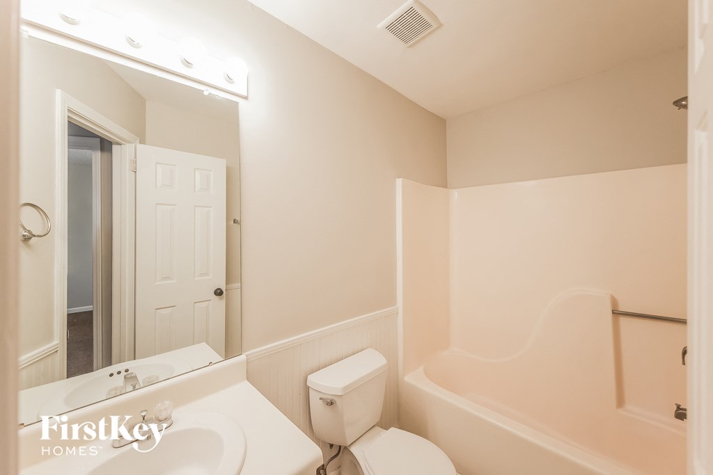 a bathroom with a toilet and a sink and a bath tub