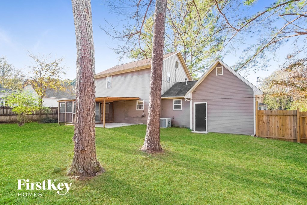 a backyard with two trees and a house