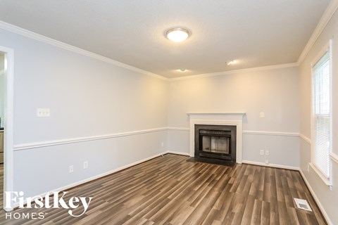the living room with wood flooring and a fireplace