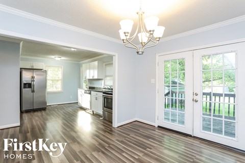 a kitchen with a door to a balcony and a stainless steel refrigerator