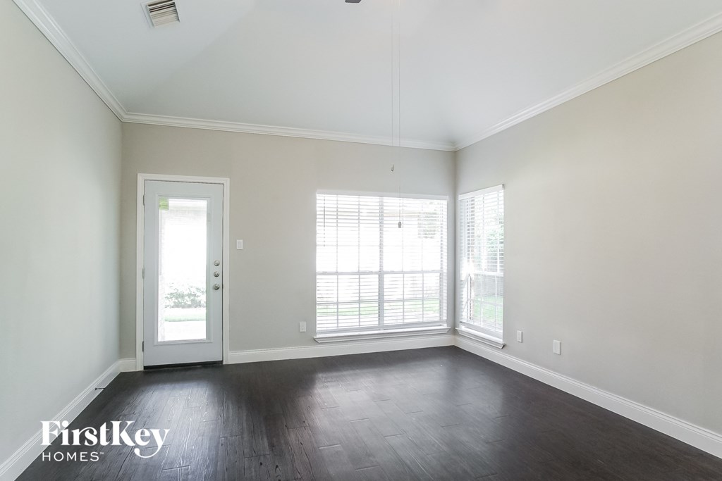 an empty living room with wood floors and white walls