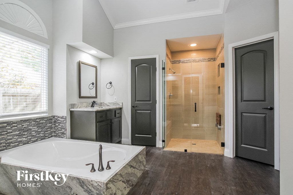 the master bathroom has a large tub and a walk in shower