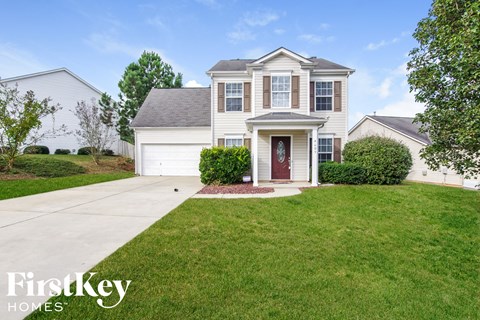 A house with a red door and a garage is for sale.
