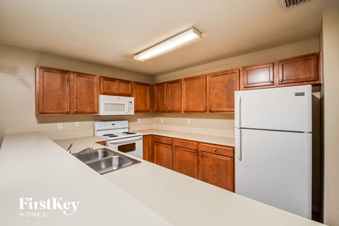 A kitchen with wooden cabinets and a white fridge.