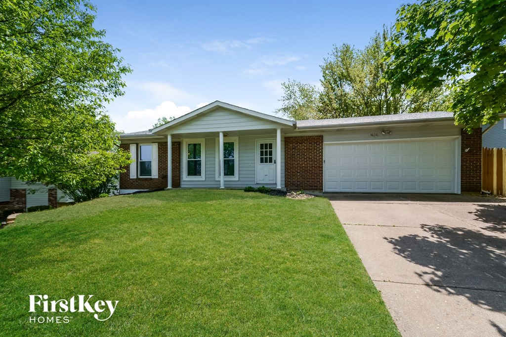 a home with a lawn and a white garage door