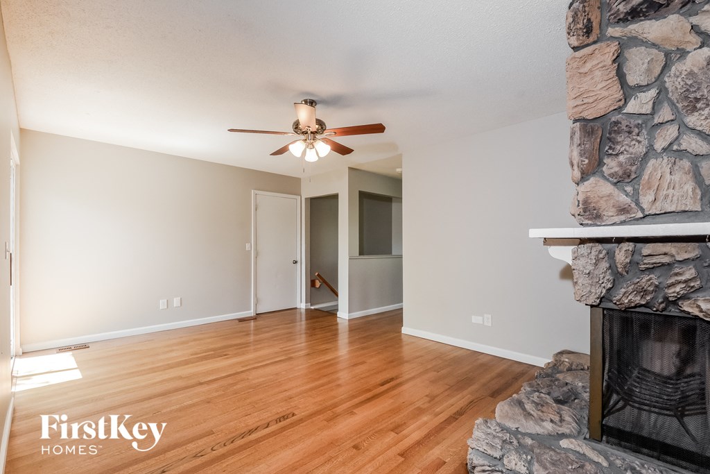 a living room with a fireplace and a ceiling fan