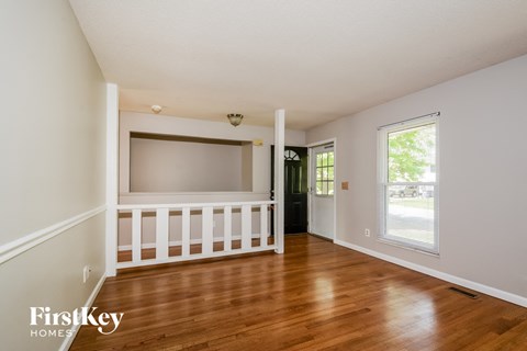 a living room with wooden floors and a large screen tv