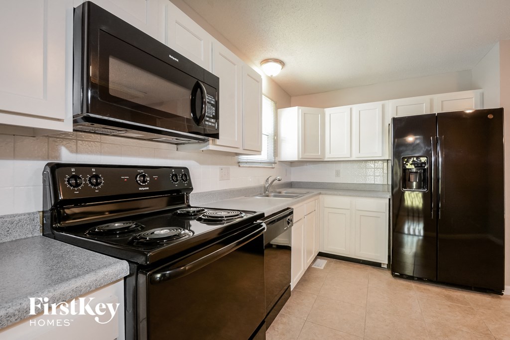 a kitchen with stainless steel appliances and white cabinets