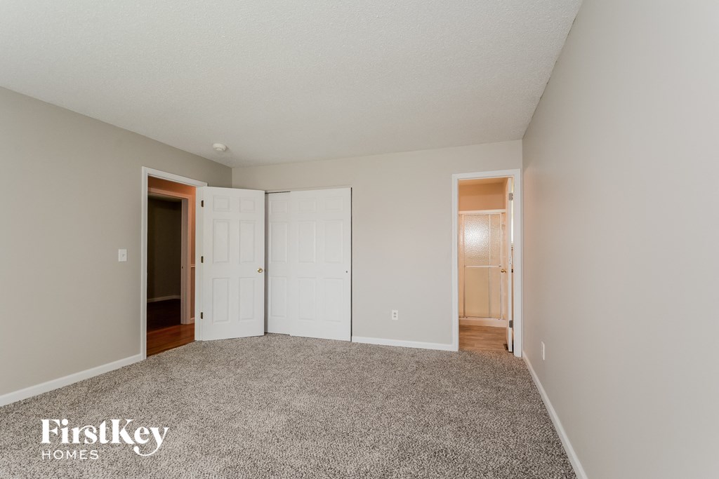 a bedroom with a carpeted floor and white doors