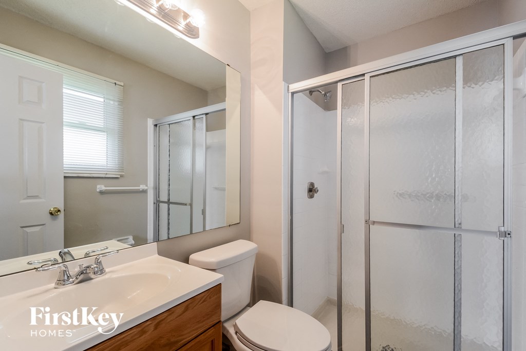a bathroom with a shower and a sink and a toilet