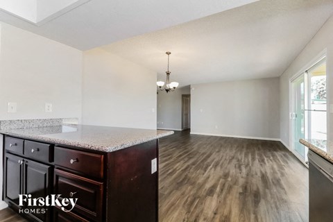 A kitchen with dark wood cabinets and a granite countertop.