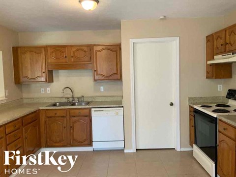 A kitchen with wooden cabinets and a white door.