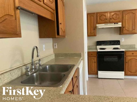 A kitchen with a sink and a stove top oven.