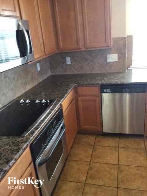 a kitchen with granite counter tops and a stainless steel stove