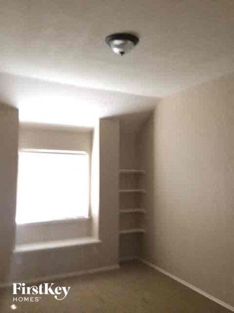 an empty room with a window and a light on the ceiling