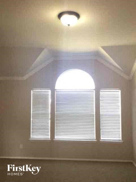 an empty room with a window and a light on the ceiling