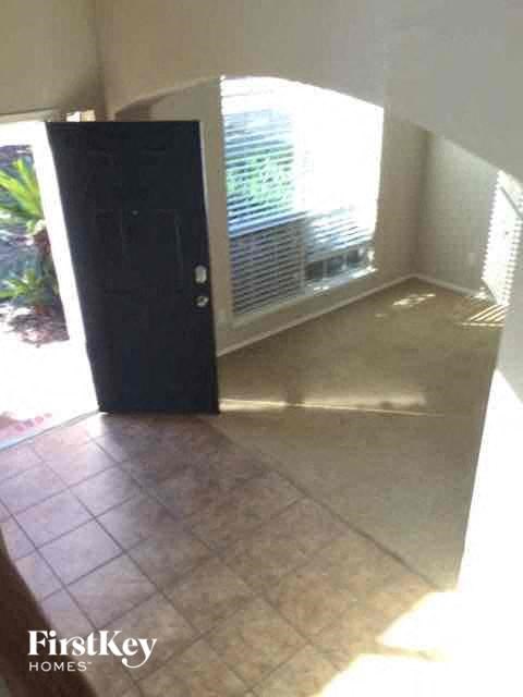 an empty room with a black door and a window