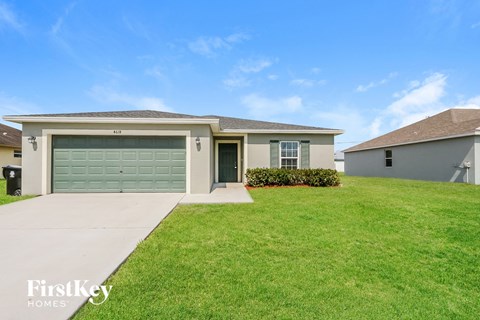 a house with a green garage door and a lawn