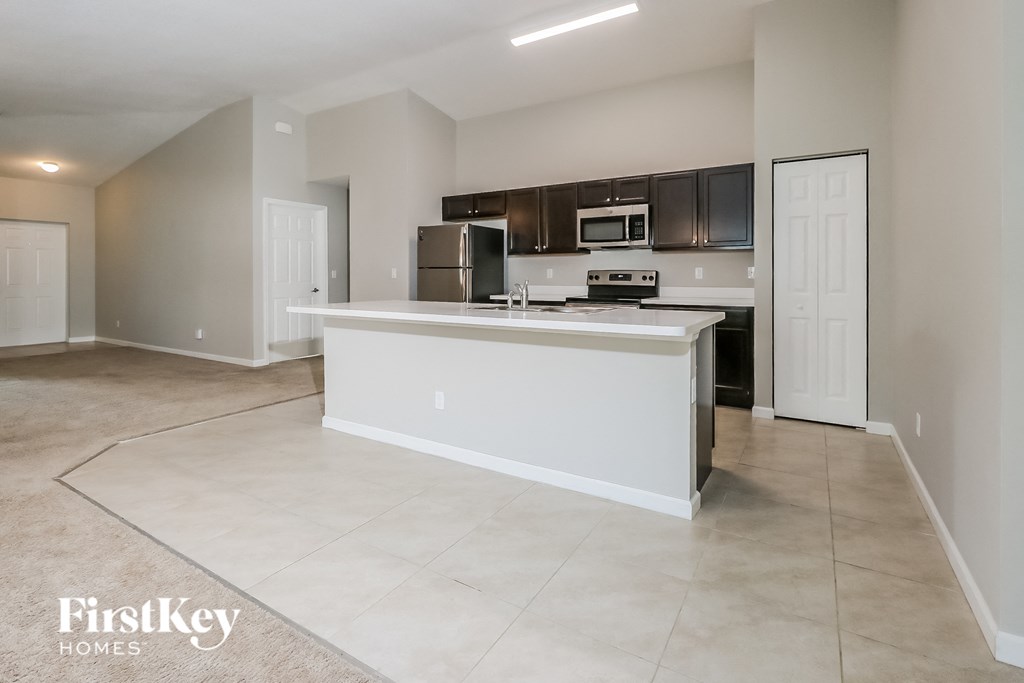 an empty kitchen with an island in the middle of it