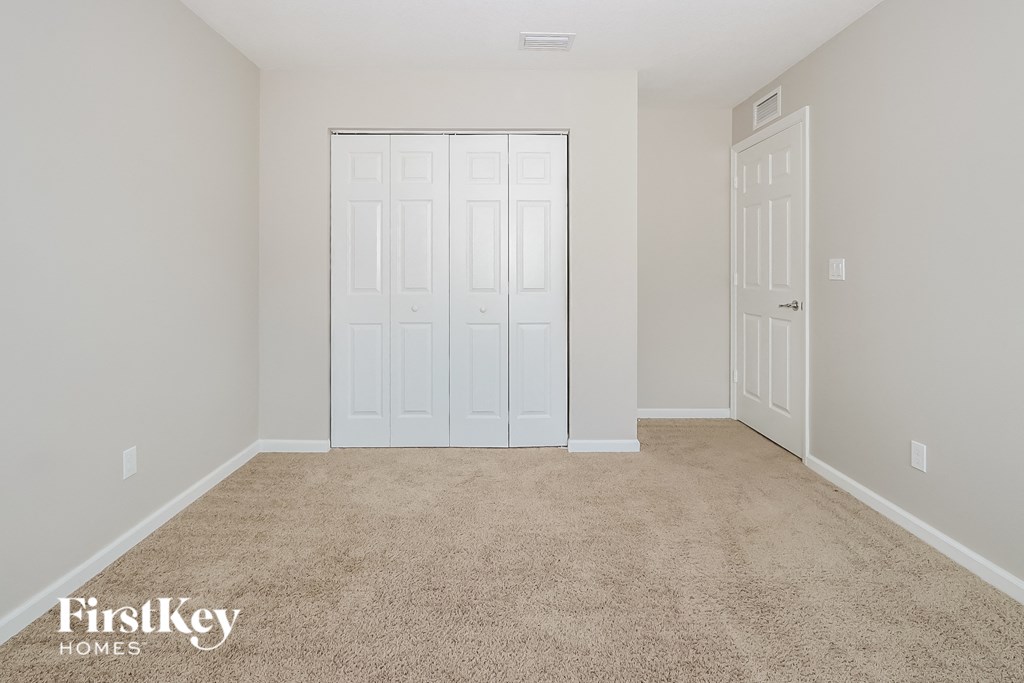 a room with a carpeted floor and white doors