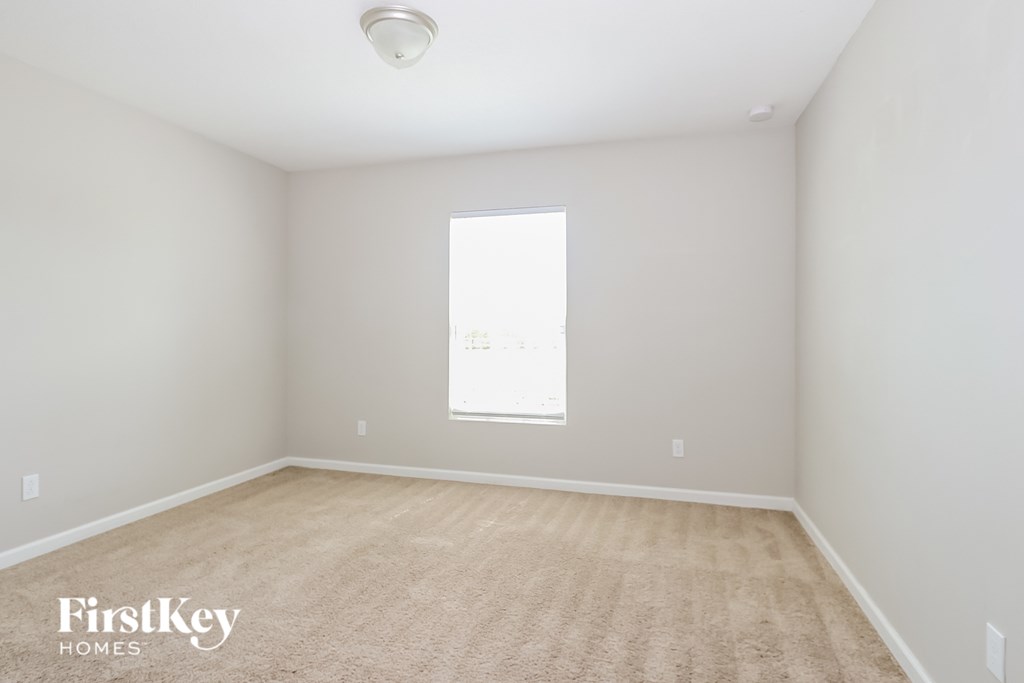 a spacious room with white walls and a window