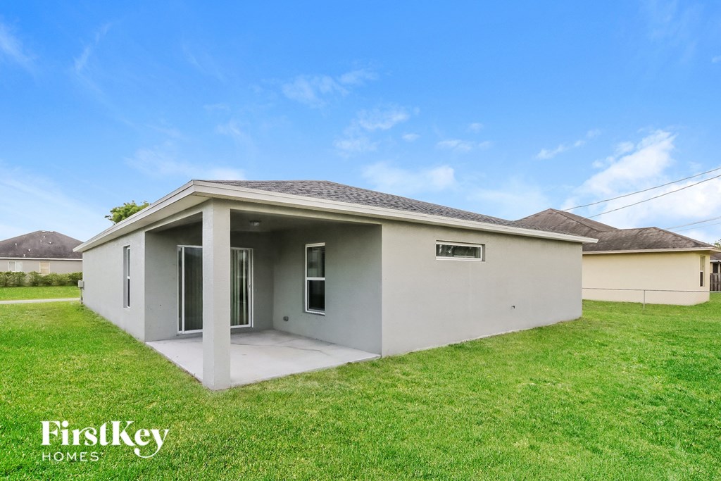 a small white house with a lawn and a blue sky