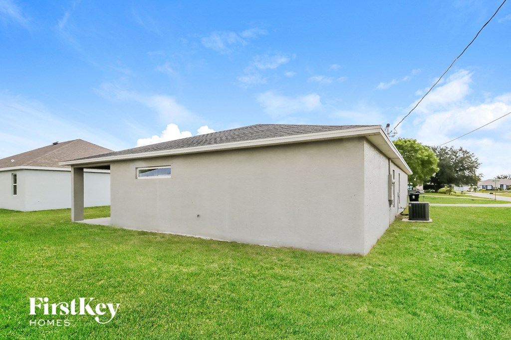 the view of a small white house with a grassy yard