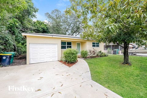 a yellow house with a driveway and a white garage door