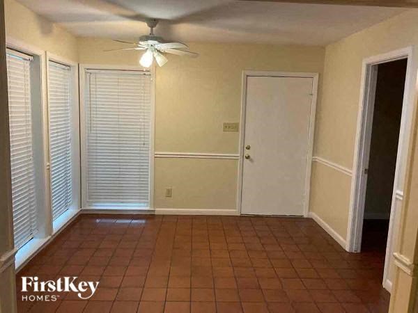 A room with a ceiling fan and tile flooring.