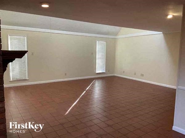 A room with a tiled floor and a window with blinds.