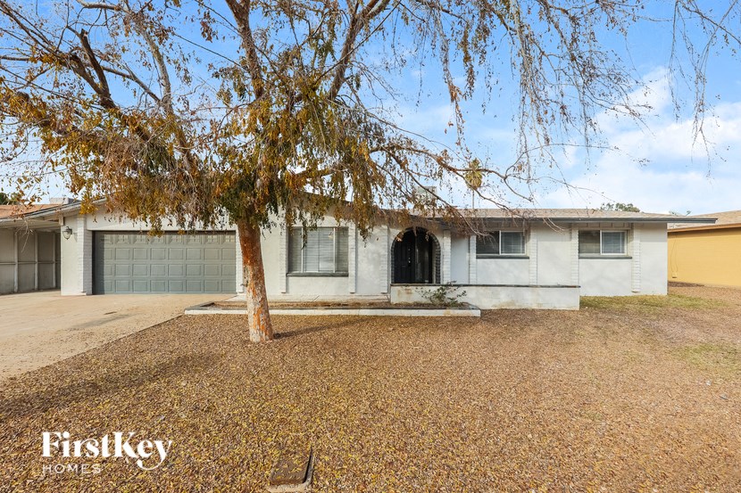 a white house with a tree in front of it