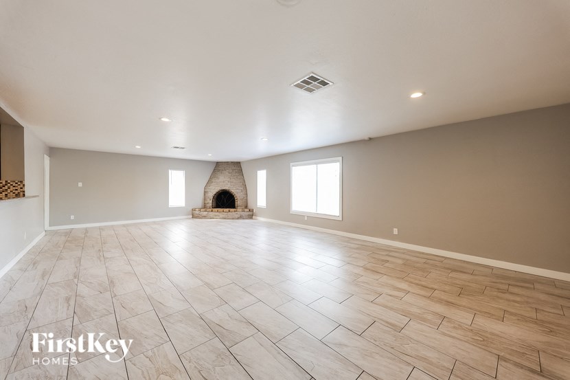 a large living room with a fireplace and tile flooring