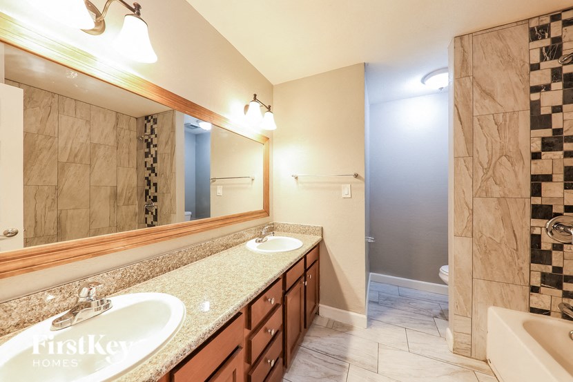 a bathroom with two sinks and a shower and a large mirror
